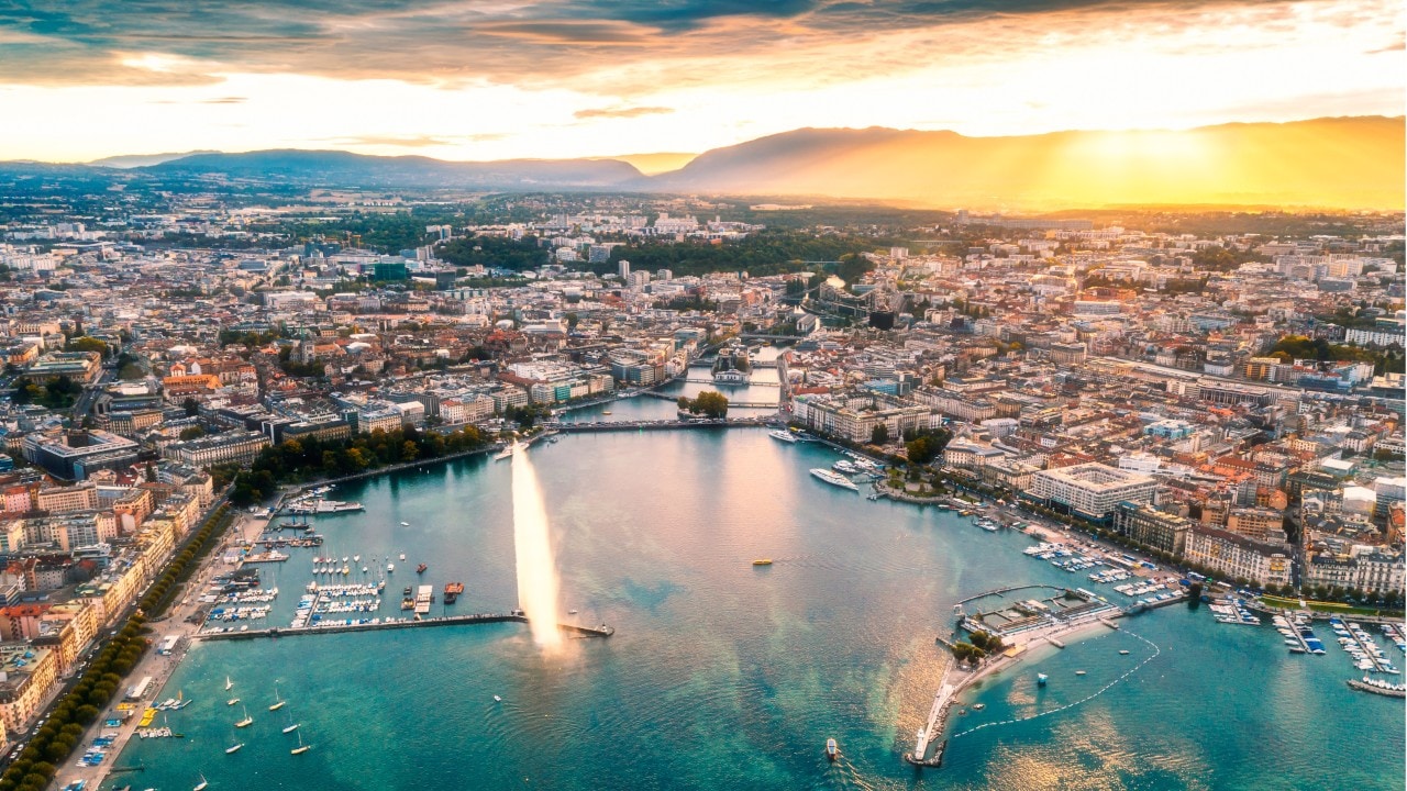 high angle view of Geneva city panoramic from drone point at sunset with famous travel destination jet d'eau and Geneva Lake.