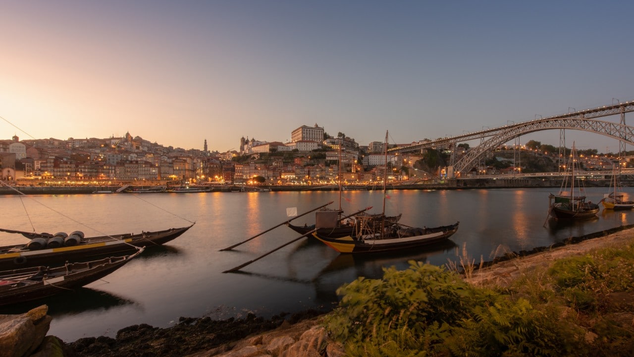 Porto cityscape in sunset with river on the front and wine carrier ship in  foreground and city of Porto in background, Portugal.